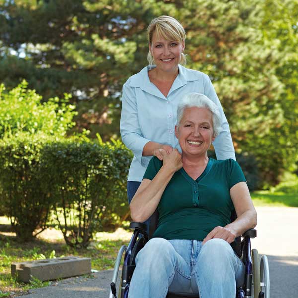 Frau im Rollstuhl mit Betreuerin
